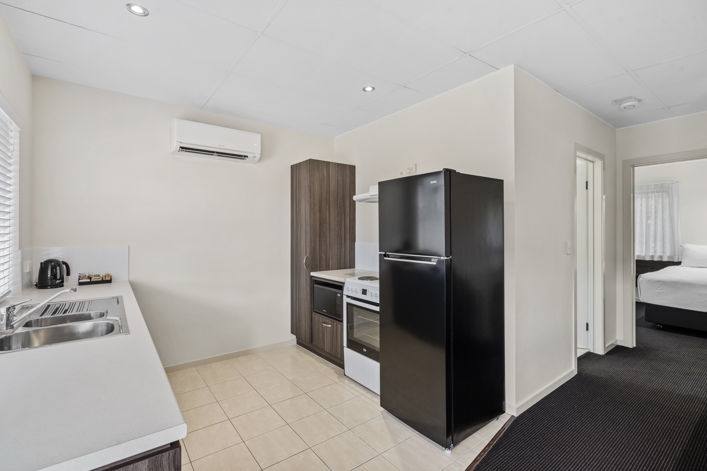 A villa kitchen with full-size appliances, opening to the bedroom