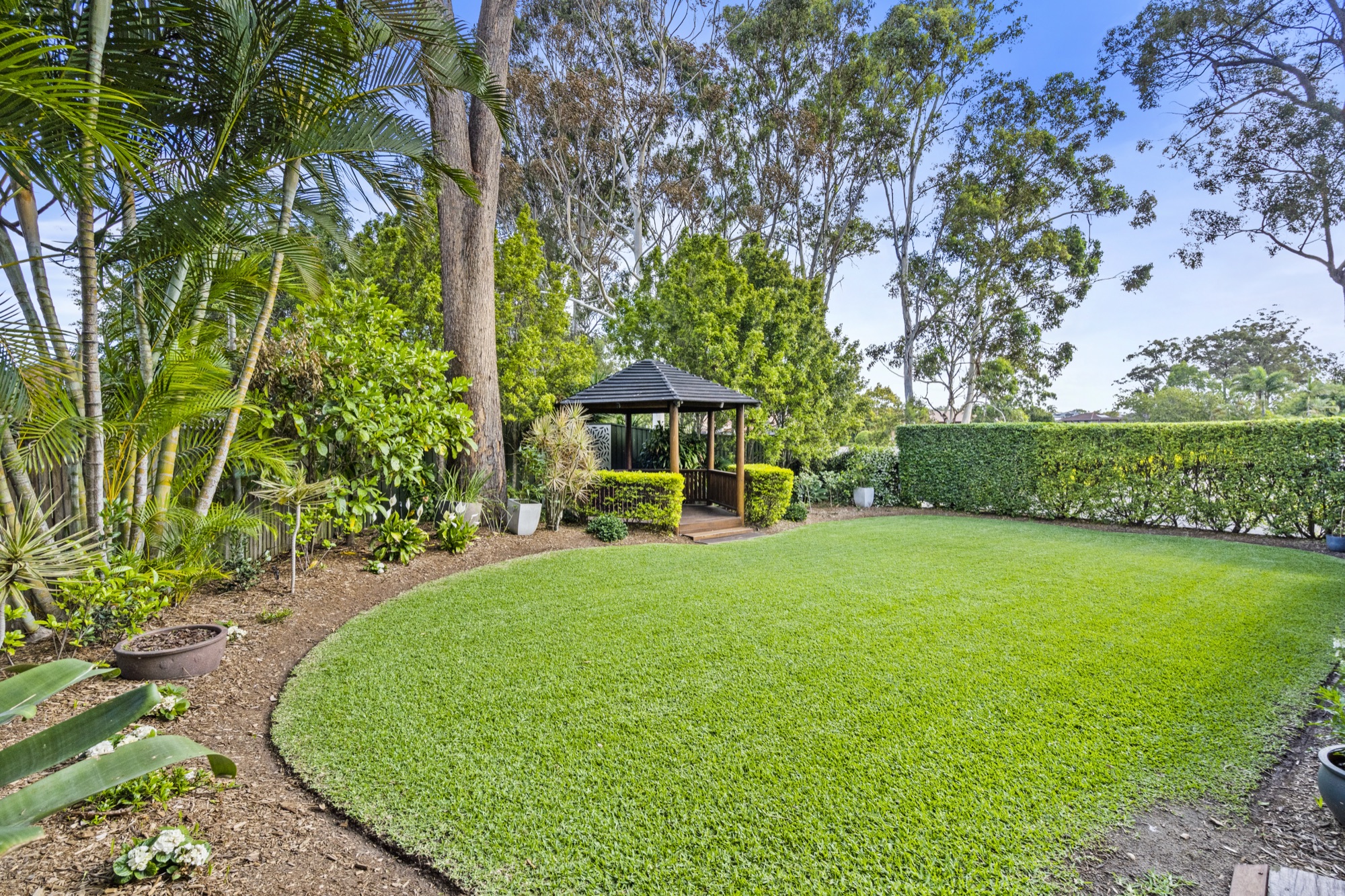 A garden lawn and rotunda among the trees