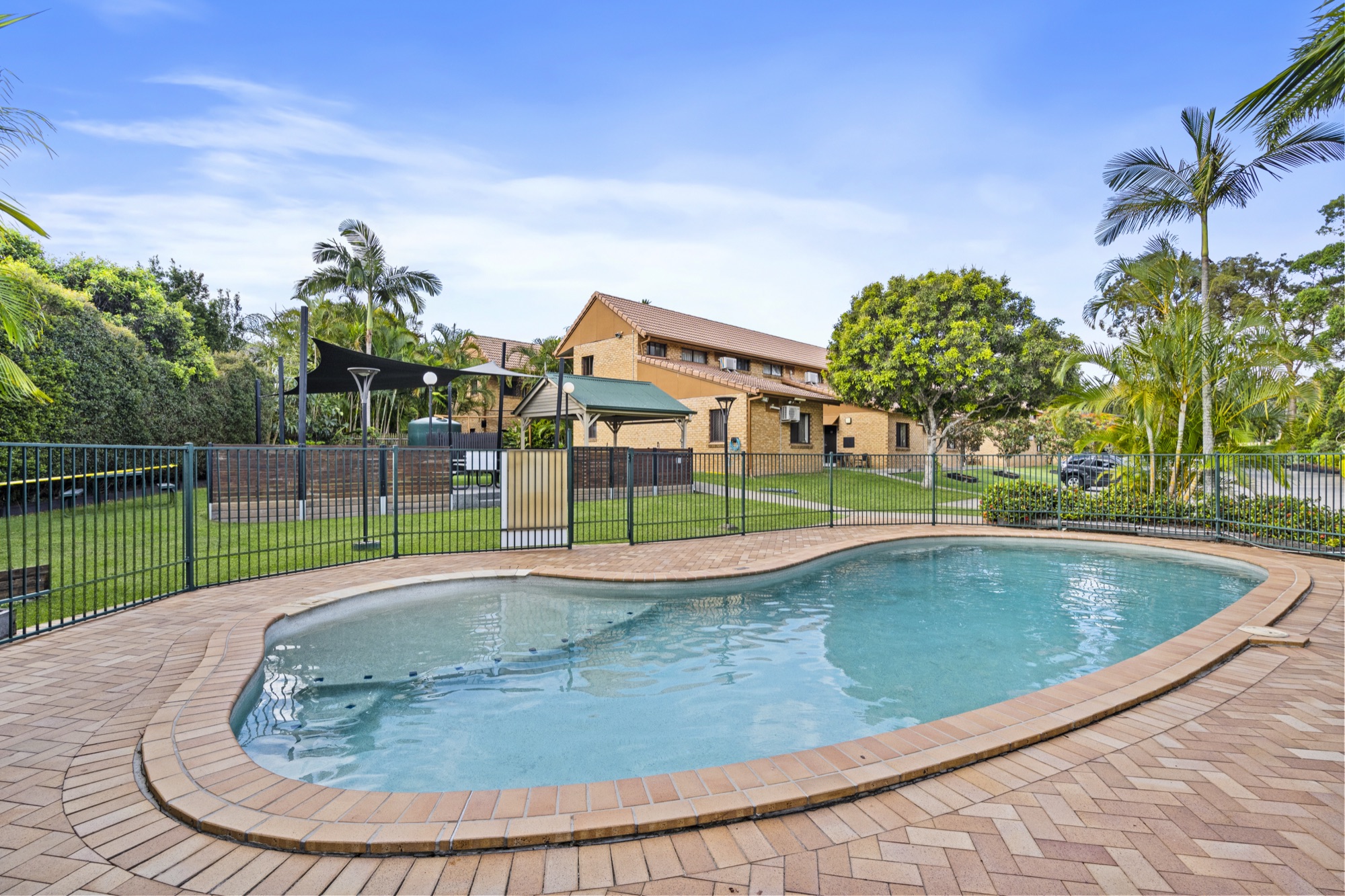 The outdoor swimming pool surrounded by gardens
